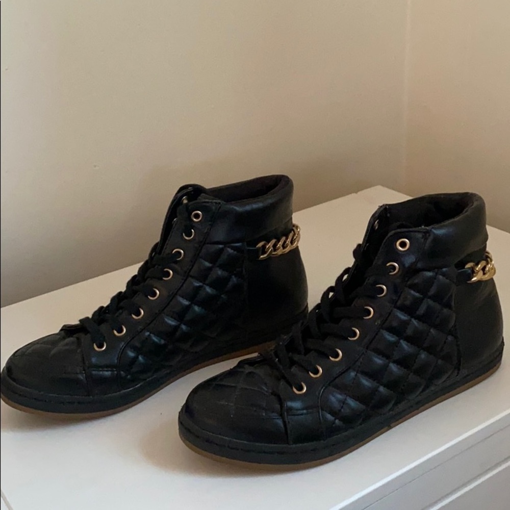Black sneaker with gold chain detail on the back
